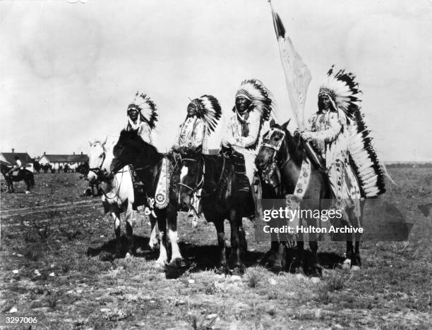 Four native Indian Chiefs. From left, Calf Child, Herbert Lawrence, Medicine Owl and Charlie Rye Eater on horseback in traditional dress and...