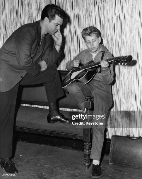Year-old rock 'n' roll discovery Mike Jackson rehearses for the TV show 'Oh Boy' while American singer-songwriter Conway Twitty listens in. The show...