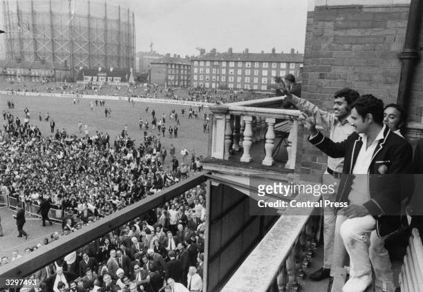 Indian skipper Ajit Wadekar and teammate B S Chandraserhar wave to cheering crowds at the Oval after India won the Test Series against England.
