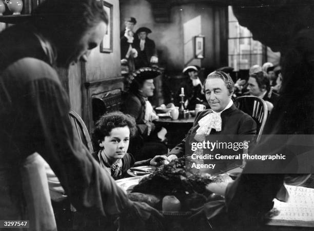 Freddie Bartholomew , the British child actor, is being offered a job by Sir Guy Standing the British stage actor, in a scene from 'Lloyd's Of...