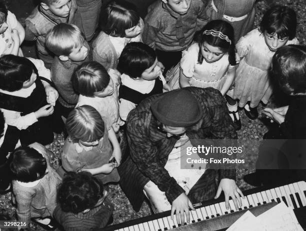 Children rehearsing for a Blackpool pantomime gathered round the piano player.