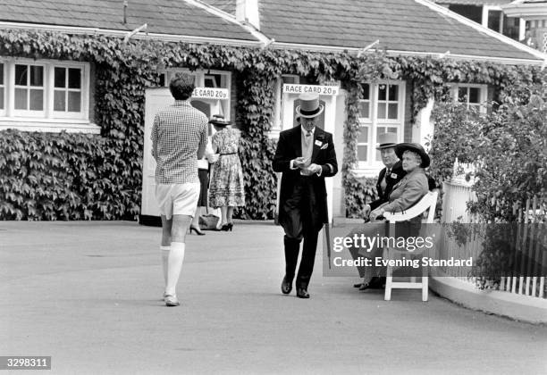 Spectators collecting race cards at Ascot.