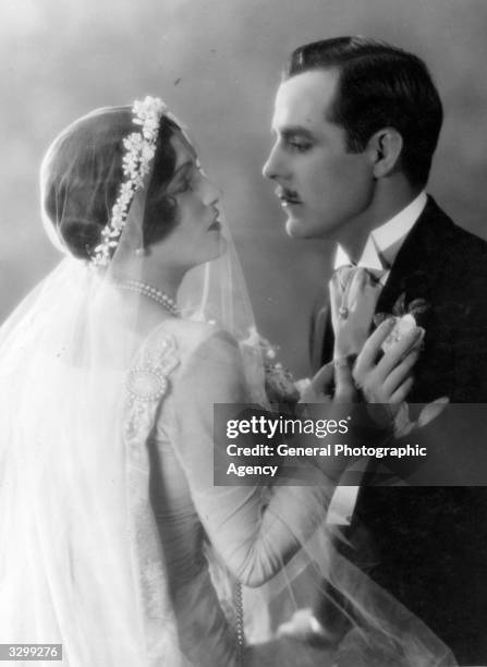 American actress Pauline Starke wearing a wedding dress and being embraced by Spanish romantic lead Antonio Moreno in the MGM film 'Love's...