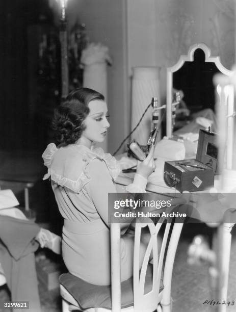 Frances Drake applies a few last minute touches to her make-up before going onto the set of her latest film, 'Ladies Should Listen', directed by...