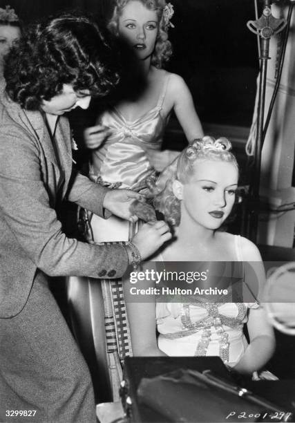 Hollywood film star Betty Grable , whose legs are reputed to have been insured for a million dollars, has her hair arranged prior to filming a scene...