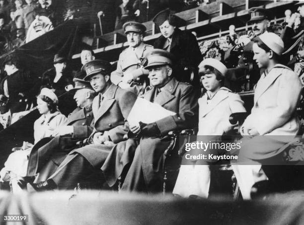 King Leopold III of Belgium , accompanied by his three children, Baudouin, , Albert, Prince of Leige and Princess Josephine Charlotte, and officers,...