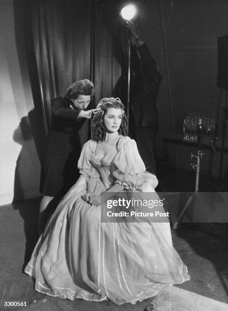 Actress Patricia Roc having adjustments made to her hair during the filming of 'The Wicked Lady', the story of a 17th century highwaywoman, directed...