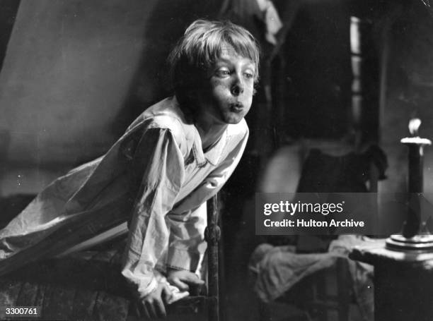 Young actor Robert Lynen blows out a candle in a scene from the French film 'Poil De Carotte', directed by Julien Duvivier.