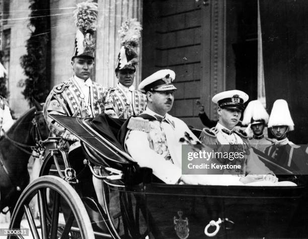 Carol II , king of Romania from 1930 to 1940, en route to open the new parliament in an open carriage with Crown Prince Michael, later King Michael...
