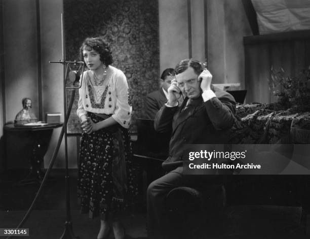 Bebe Daniels works on the musical score with Otto Morendo, her singing teacher during the filming of the film 'Rio Rita', directed by Luther Reed for...