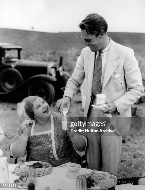 Randolph Scott and Kate Smith taking refreshments during the production of 'Hello Everybody'. The film was directed by William Seiter for Paramount.