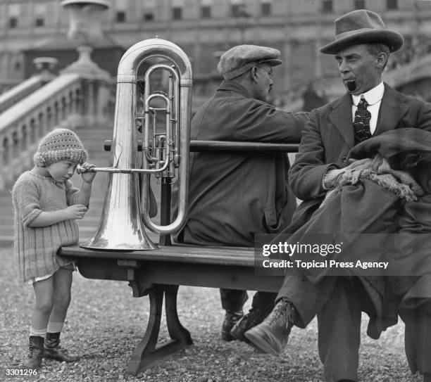 Young girl looking into the mouthpiece of a tuba during the National Band Festival at Crystal Palace, south London.