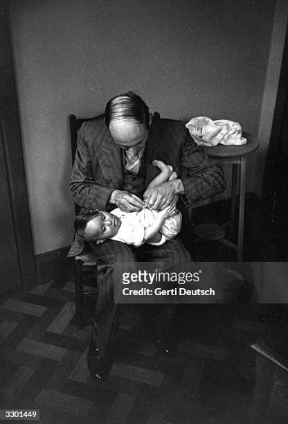 Father changes his child's nappy in a class organised by the Mothercraft Training Society, at their centre in Kingston-on-Thames. Original...