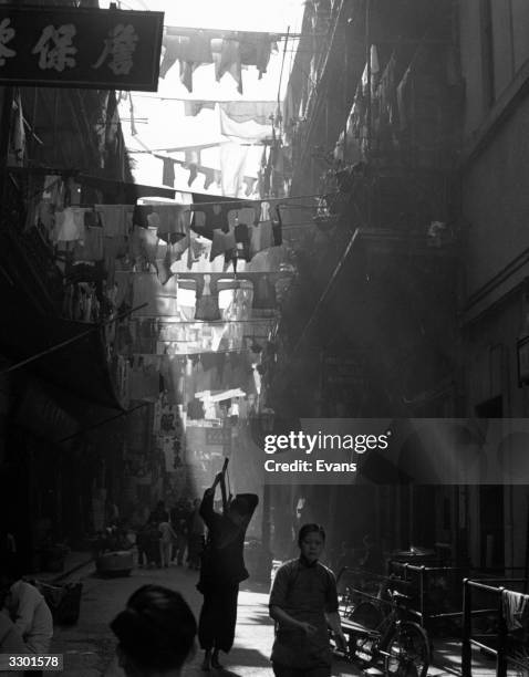 Narrow street in Hong Kong with washing lines hanging between the houses.