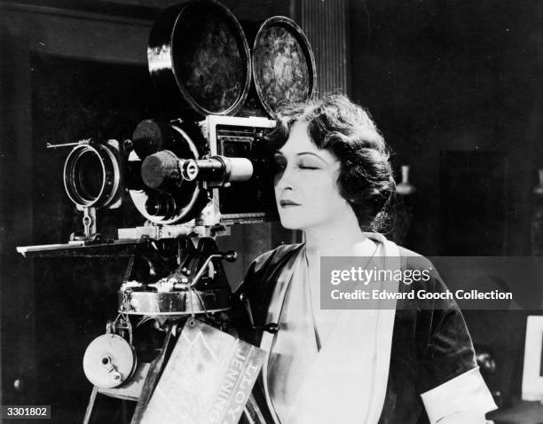 American actress Pauline Frederick takes a look through the camera, on the set of the film 'The Woman In Room Thirteen'.