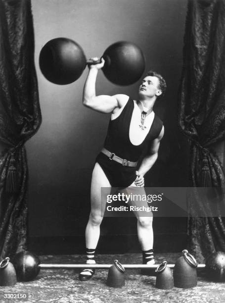 German strong-man Eugene Sandow lifting weights and dumbbells.