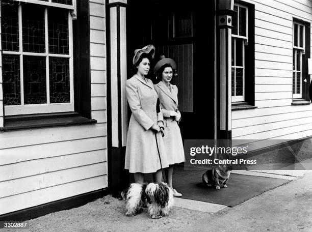 Princess Elizabeth and Princess Margaret Rose waiting at Ballater Station, near Balmoral Castle, Aberdeenshire, with two dogs. Queen Victoria's...