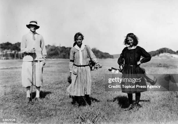 Edward, Prince of Wales playing golf in Le Touquet, France accompanied by two girl caddies.