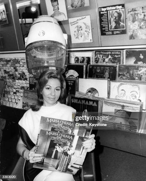 Italian opera singer Maria Chiara sitting under a hairdryer with two copies of her latest record after opening the record shop 'Sounds of St James's'...