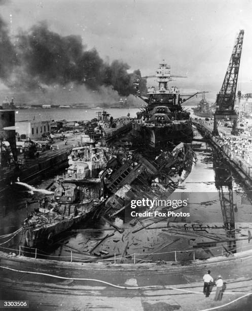 The jumbled mass of wreckage in front of the battleship USS Pennsylvania constitutes the remains of the destroyers USS Downes and USS Cassin, bombed...