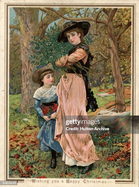 Young girls collecting mistletoe in the woods, on this Victorian greetings card.