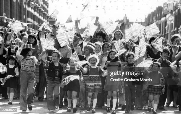 Children waving flags in a Jubilee celebration in Kingswood Road, Fulham.