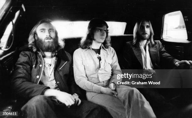 British rock group Genesis, from left to right Phil Collins, Tony Banks and Mike Rutherford, in the back of a limousine on the way to the LA Forum...
