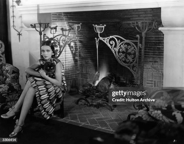 Dolores Del Rio Hollywood film star and wife of MGM's Art Director Cedric Gibbons. Sitting by the fire with her cat 'Joan'.