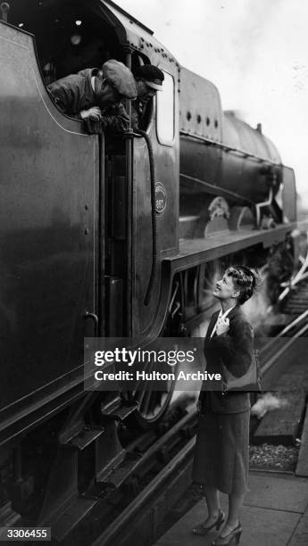 Ellen Drew the screen name of Terry Ray, the Hollywood film actress, talks to the engine driver and fireman of her train at Waterloo station.