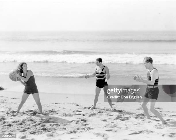 Lillian Roth the Hollywood film star, actress, dancer and singer who appeared in 'The Vagabond King, a Paramount picture, plays on the beach with...