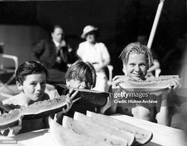 Mickey Rooney, seen here with Freddie Bartholomew on his right and Jackie Cooper, all young fellow artists in Hollywood consuming large quantities of...
