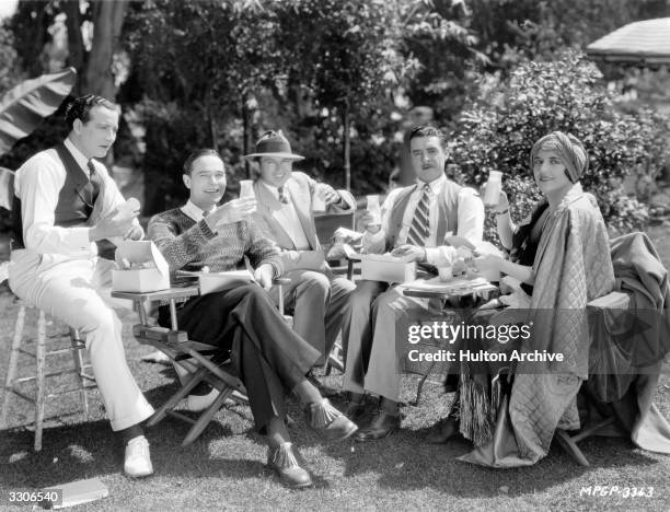 King Vidor the American director with John Gilbert the leading man and Aileen Pringle join William Haines in a snack between filming scenes of his...