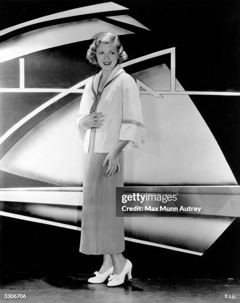 American actress Claire Trevor , formerly Claire Wemlinger wearing a red crepe frock with a collar of red and white pique designed by Royer. The...
