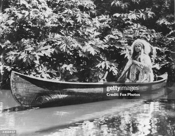 Chief Os-Ke-Non-Ton paddles his canoe on the lake in Regent's Park. He is in London, from Canada, to play the leading part in a stage production of...