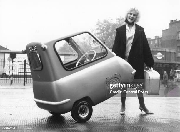 The world's smallest car, PEEL 50, is easy to park and easy to pick up, as model Karen Burch demonstrates at its debut at the Earls Court motorcycle...