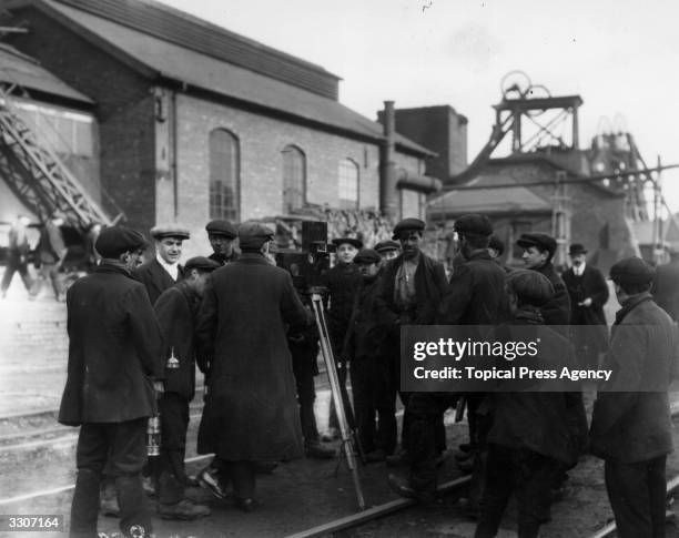 Miners in Derbyshire surrounding a cinematographer at work.