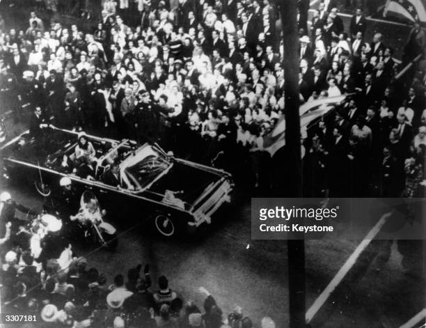 Statesman John F Kennedy, 35th president of the US, and First Lady Jacqueline Kennedy traveling in the presidential motorcade at Dallas, shortly...