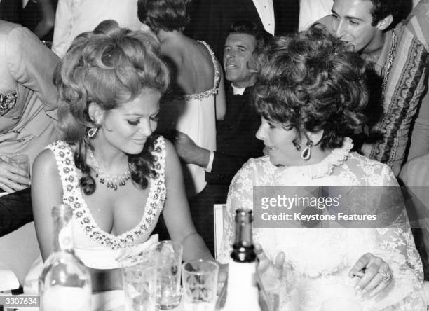 Film actress Elizabeth Taylor with Italian actress Claudia Cardinale at a charity ball in Venice during the Film Festival.