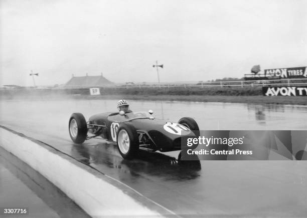 Scottish Formula 1 racing driver Innes Ireland practising in the rain in his Lotus at Silverstone during preparation for the British Grand Prix....