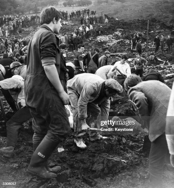 Rescue workers clearing debris and sludge near the wrecked Pantglas Junior School at Aberfan, South Wales, where a coal tip collapsed killing many...