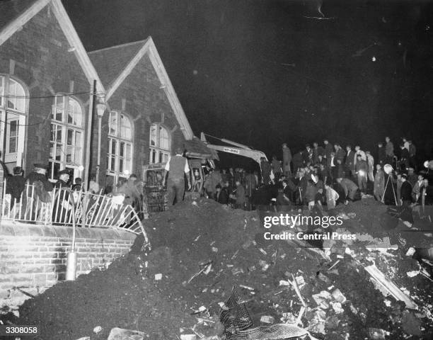 Mechanical digger goes to work clearing rubble from the crushed village school at Aberfan, South Wales, which was engulfed after a coal tip collapsed...
