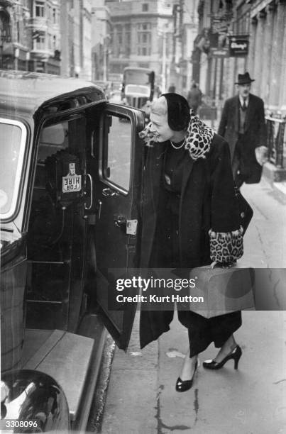 English model Barbara Allen takes a taxi back to work after lunching in a London restaurant. Original Publication: Picture Post - 5010 - The Models...