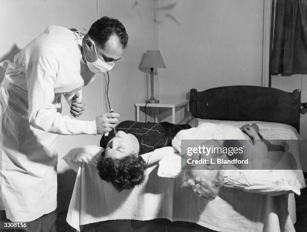 Patient is being given a virus infection by a doctor at the Common Cold Research Unit at Harvard Hospital, Salisbury. Such volunteers stay for ten...