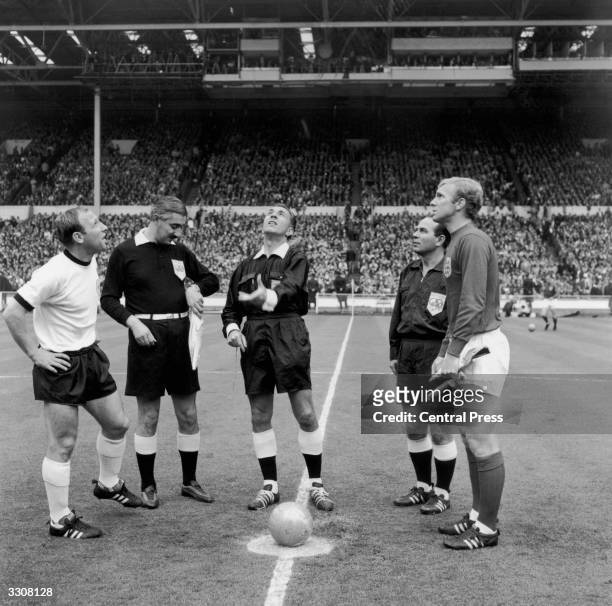 Referee Gottfried Dienst, of Switzerland, tosses the coin before the start of the World Cup final at Wembley between England and West Germany. He is...