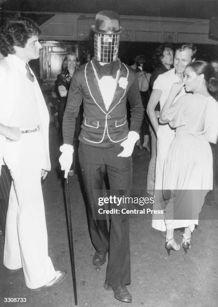 Man in costume with a mirror mask at New York's Studio 54 disco.