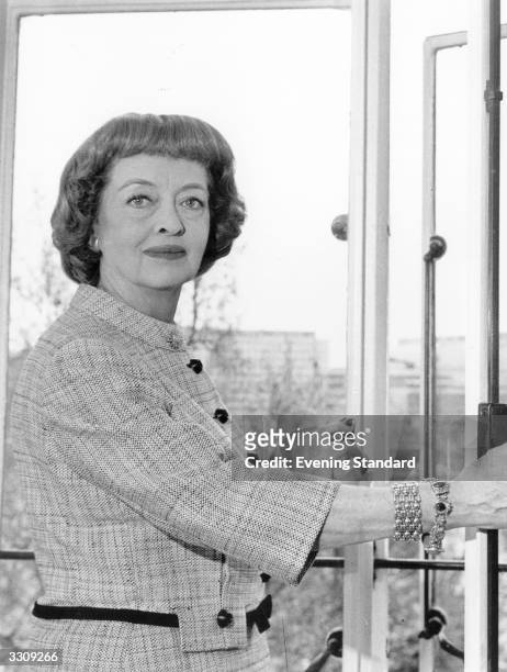 Bette Davis , the American film actress, looking at the river view from her Savoy suite.