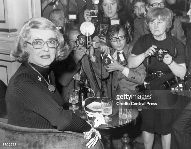 Bette Davis , American film actress, at a press conference at the London Palladium, where she will make her stage debut. Amongst the members of the...