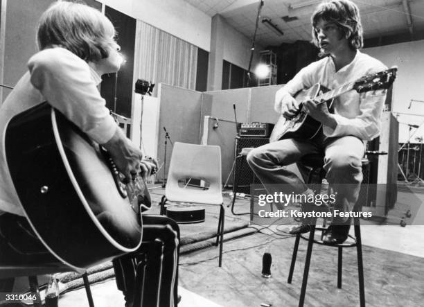 Brian Jones and Mick Jagger of the Rolling Stones jamming a tune in a recording studio, which evolved into the song 'Sympathy For The Devil', as...