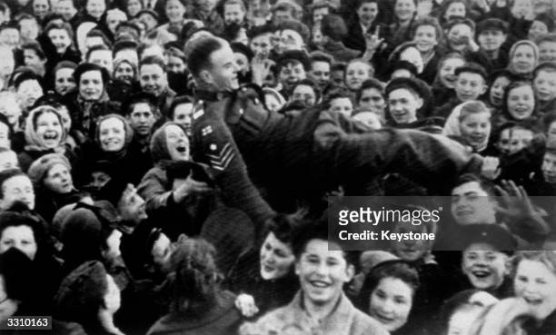 British sergeant is lifted up as Moscow women celebrate VE Day.
