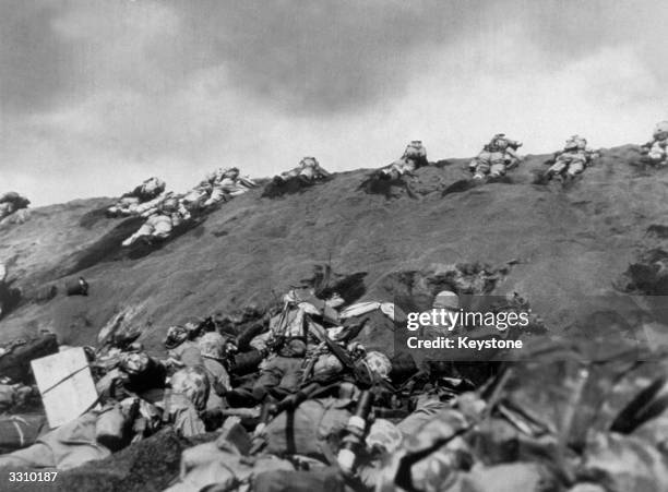 The Fifth Division Marine invaders make their way up the beach of Iwo Jima.